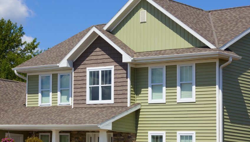 Green and Brown House of Stone, Cedar, Vinyl Siding