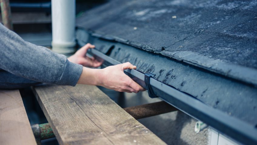 Hands of worker fixing drain